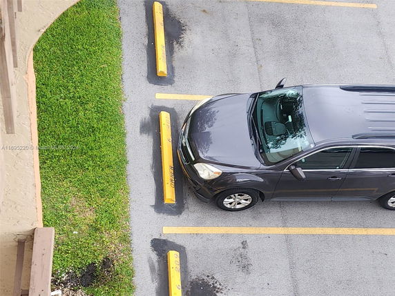 Overhead view of a parking area with a parked car in a marked space.