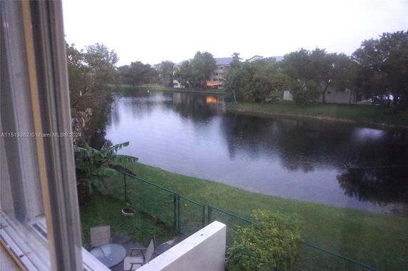 View overlooking a lake with surrounding trees and buildings.