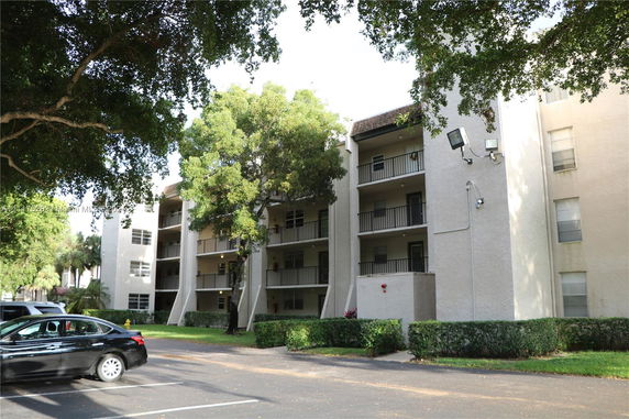 Front view of a multi-story apartment building with balconies.