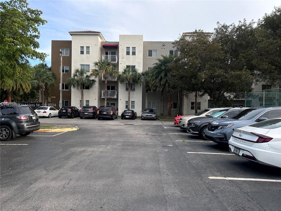 Outdoor parking area in front of a multi-story residential building.