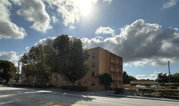 Front view of a four-story apartment building with balconies.