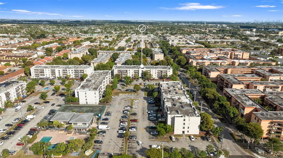 Aerial view of multiple residential buildings and parking areas in a suburban setting.