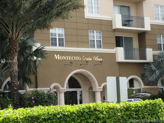 Front view of a multi-story building with balconies and archway entrance.