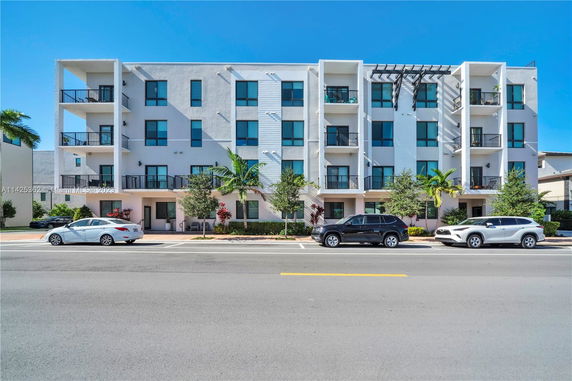 Front view of a four-story apartment building with balconies.