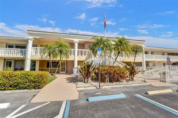 Front view of a two-story building with white columns and balconies.