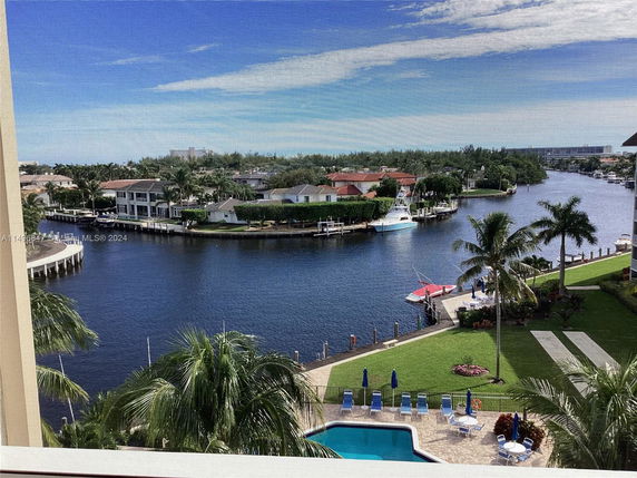 Wide angle view of a waterway with residential buildings and boats, seen from a building.