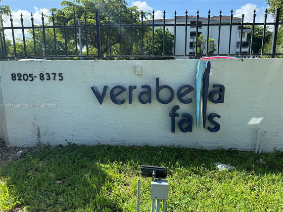 Sign for Verabella Falls with an apartment building in the background.