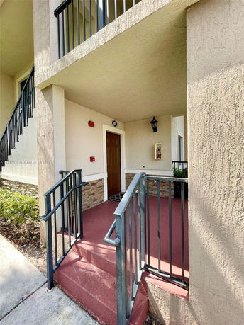 Front view of a building entrance with a small staircase and railing.