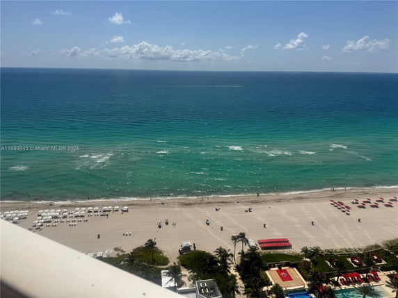Panoramic view of a beach and ocean from a building overlooking the shore.