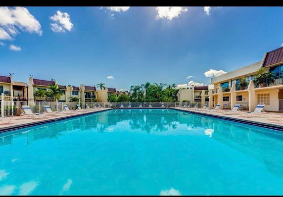 Outdoor swimming pool area surrounded by residential buildings.