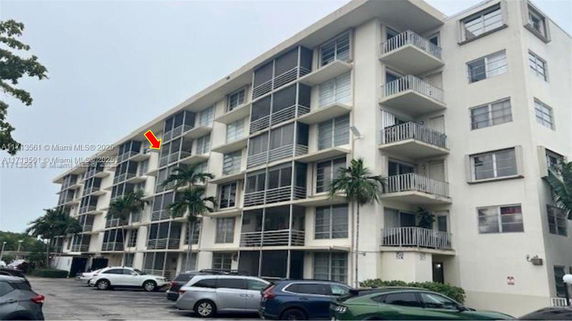 Front view of a multi-story apartment building with balconies.