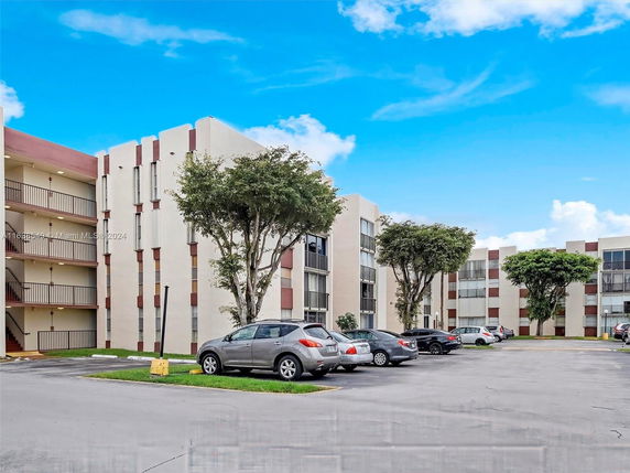 Outdoor parking area in front of a multi-story residential building.