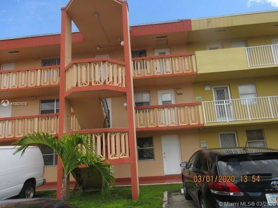 Front view of a three-story apartment building with balcony railings.