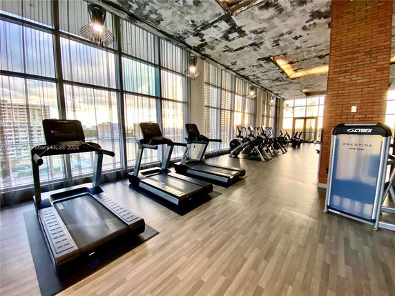 Interior view of a gym with treadmills and exercise equipment in a modern building.