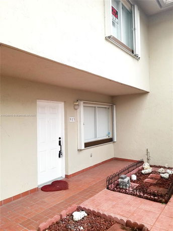 Front view of a house with a white door and a window above.