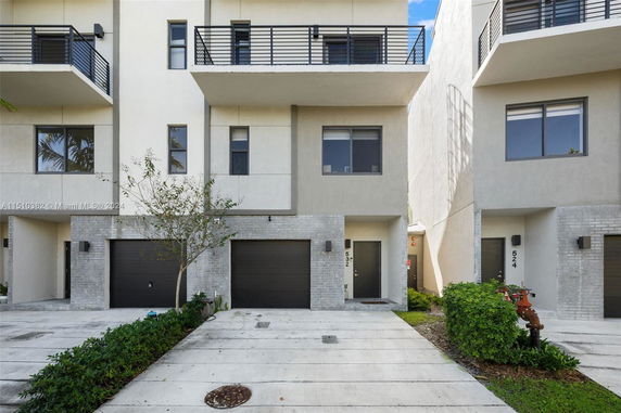 Front view of a modern multi-story townhouse with a garage.