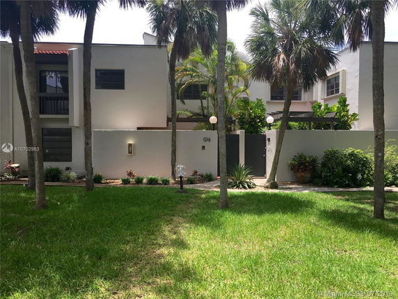 Front view of a two-story house with a modern design and a gated entrance.