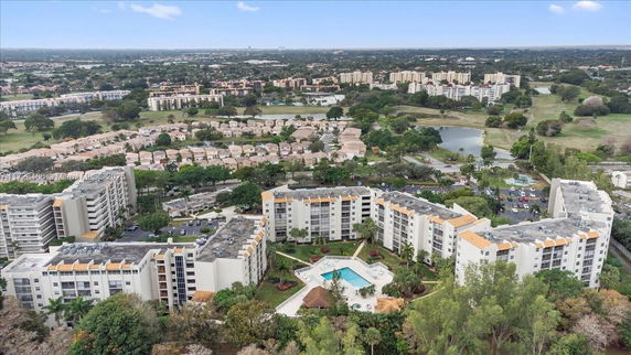 Aerial view of residential apartment complex with surrounding landscape.