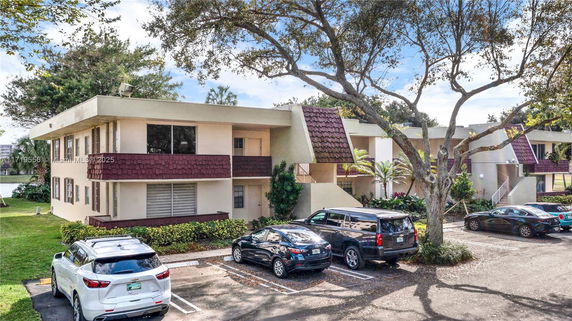 Front view of a two-story residential building with parking area.