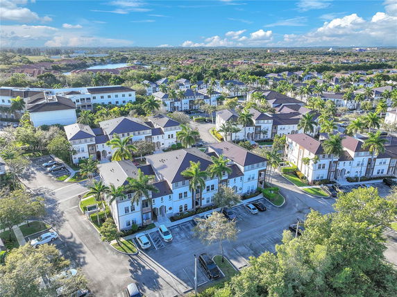 Aerial view of a residential neighborhood with multiple two-story houses and surrounding greenery.