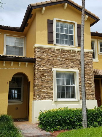 Front view of a two-story house with stone and stucco exterior.
