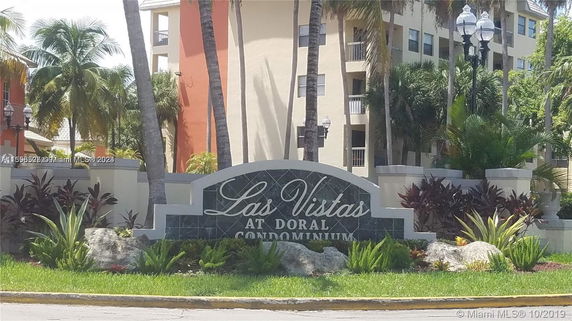 Front view of Las Vistas at Doral Condominium with landscaping and a sign.