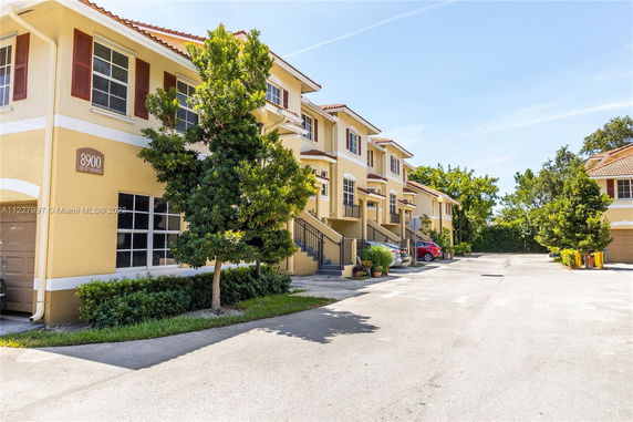 Front view of a two-story townhouse building with multiple units and garages.
