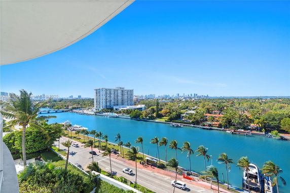 Panoramic view of a river with surrounding buildings and trees.
