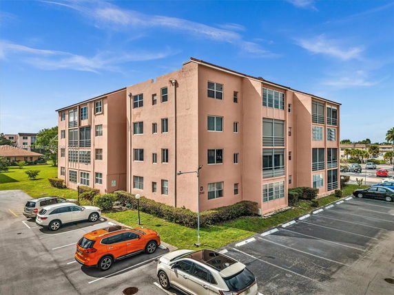 Front view of a multi-story apartment building with multiple windows.