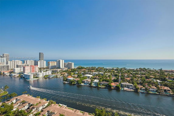 Wide panoramic view of a coastal cityscape with high-rise buildings and waterway.
