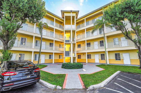 Front view of a multi-story building with balconies and yellow facade.
