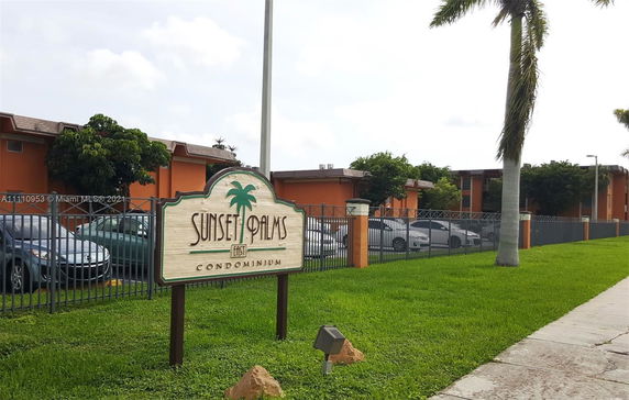 Front view of a condominium complex with an entrance sign.