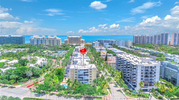 Aerial view of a coastal cityscape with tall buildings and ocean in the background.