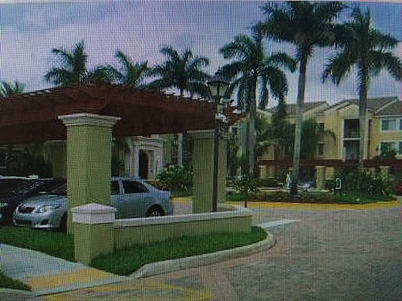 Outdoor parking area with covered parking near a residential building.