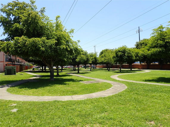 Green park area with winding pathways and trees.