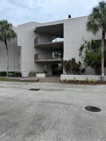 Front view of a multi-story building with open balconies.