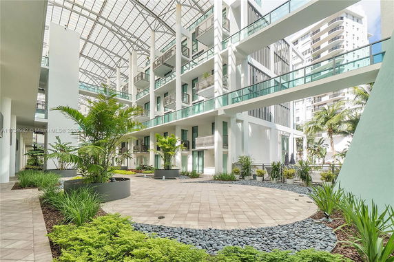 View of a building's inner courtyard with open walkways and potted plants.