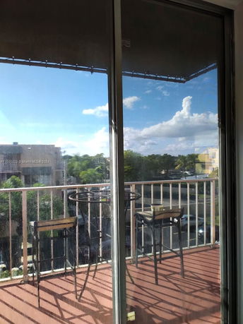 View from a balcony with outdoor furniture looking at the surrounding area.