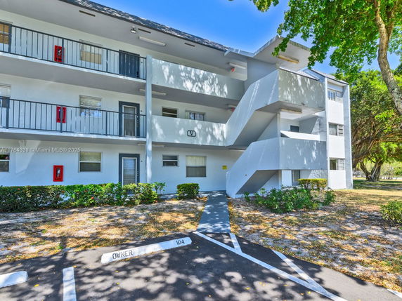 Front view of a multi-story residential building with balconies and external staircases.
