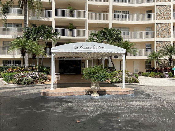 Front view of a multi-story residential building with a covered entrance.