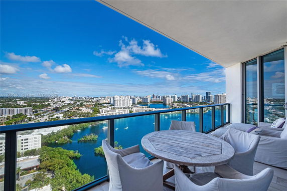 Wide angle view from a balcony overlooking the city skyline and water.