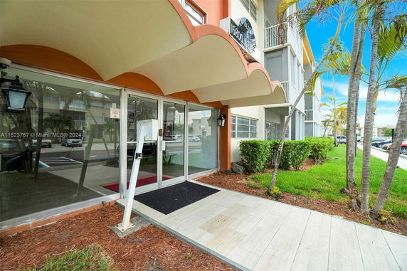 Front view of a building entrance with glass doors and canopy.