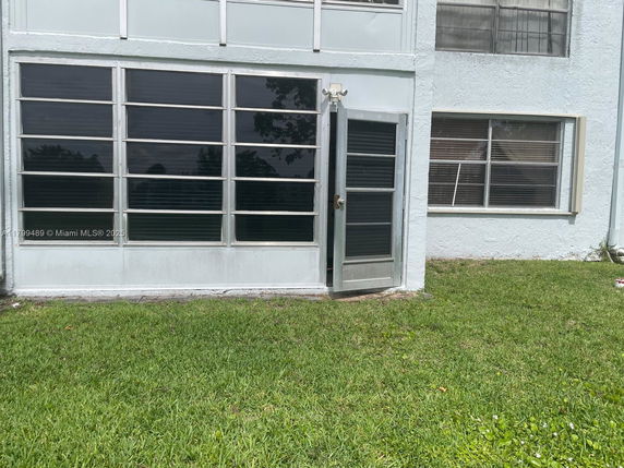 Exterior view of a building with multiple windows and a door on the ground floor.