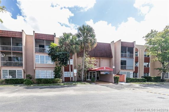 Front view of a multi-story apartment building with a central entrance.