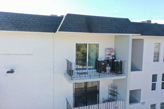 Front view of a multi-story building with a small balcony.