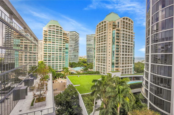 View of tall residential buildings with glazed facades and green roof areas.