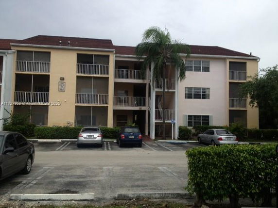Front view of a three-story apartment building with balconies.