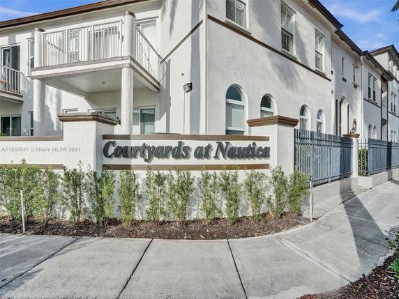 Front view of a multi-story residential building with a balcony.