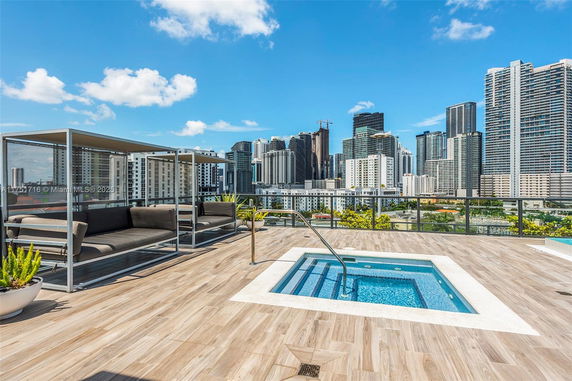 Rooftop area with urban view, featuring a small pool and seating arrangements.