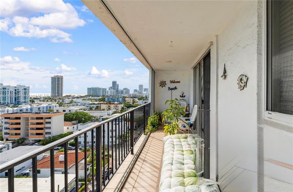 Balcony view of city skyline and nearby buildings.